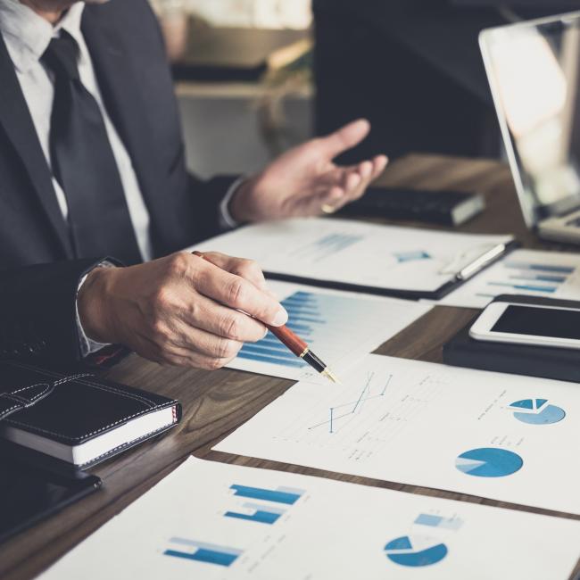 Financial expert pointing at a graph.