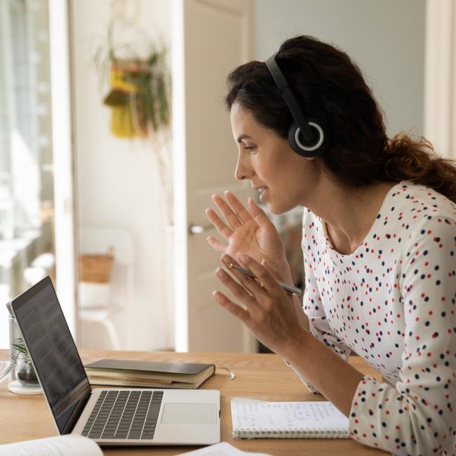 A woman with headphones on a work-related video call.