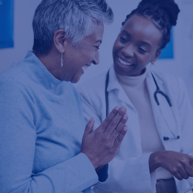 A patient and doctor look happy as they go over the patient's health results.