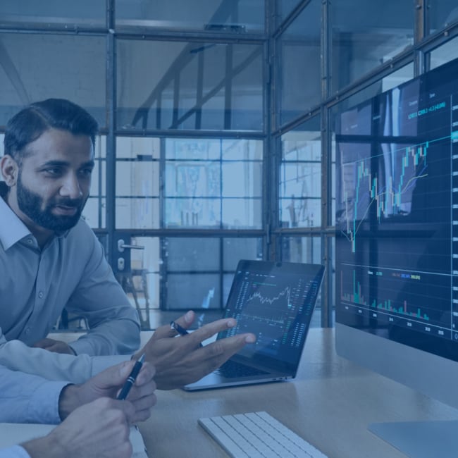 A colleague review data on a desktop computer. 