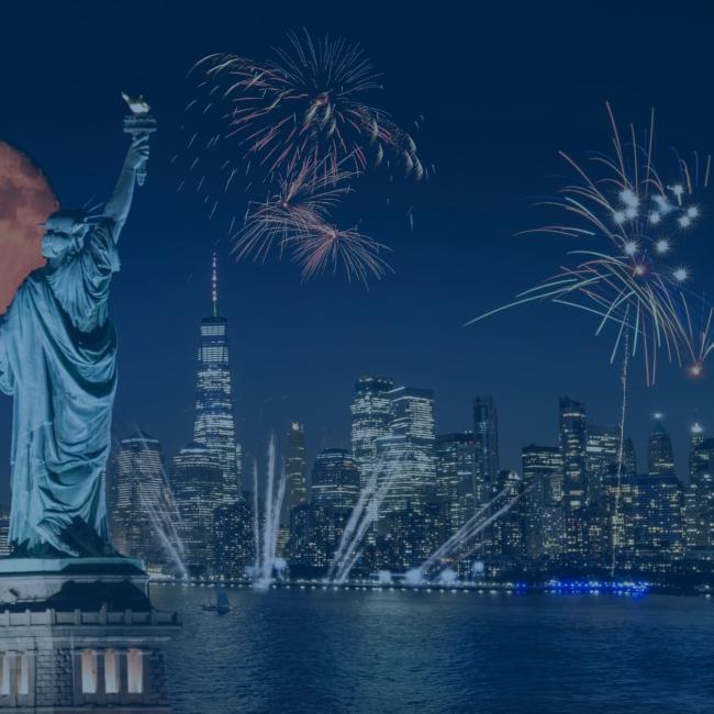 Independence Day fireworks in New York with the statue of liberty visible. 
